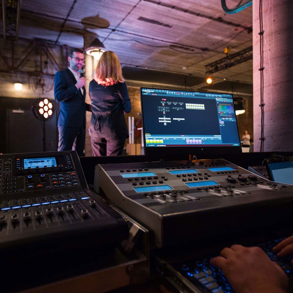 view of the backstage at a business conference through the audio visual tech's perspective