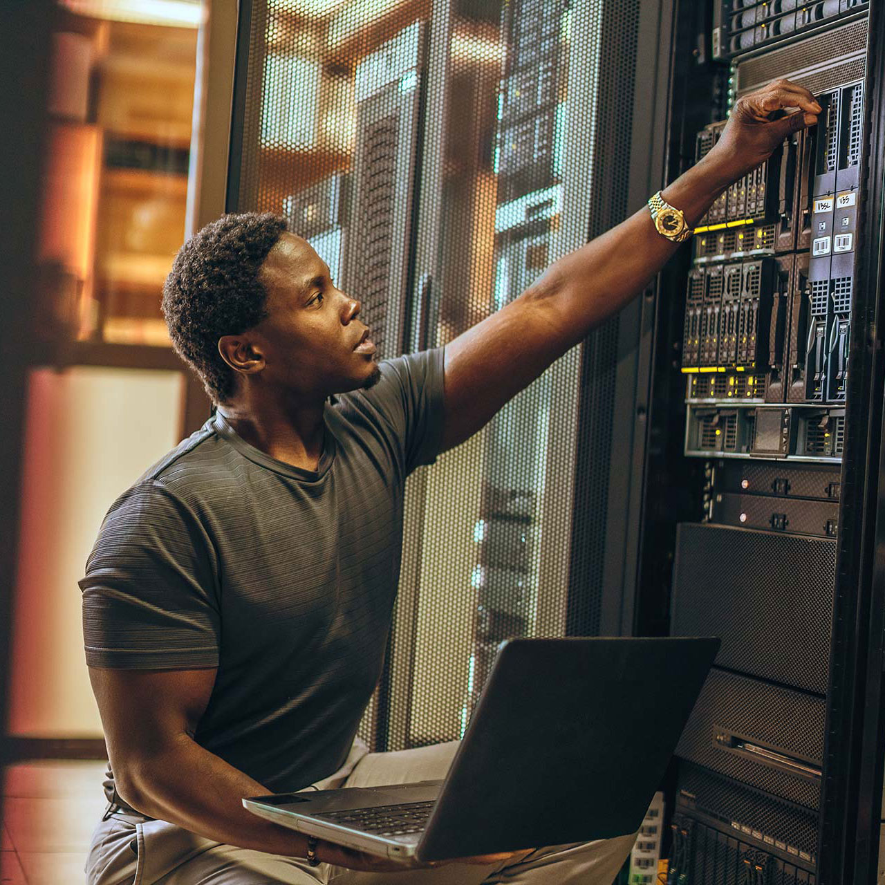 young African-American IT professional dials in settings on server