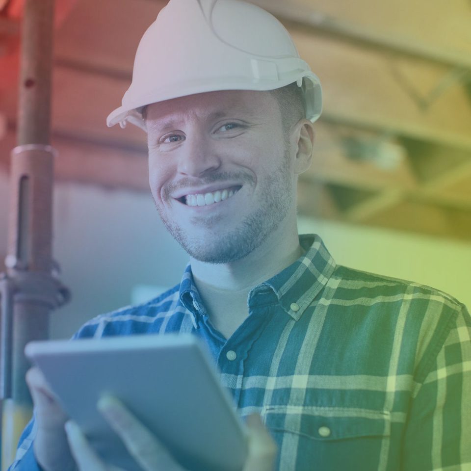 young man in white hard hat review IT solutions on laptop