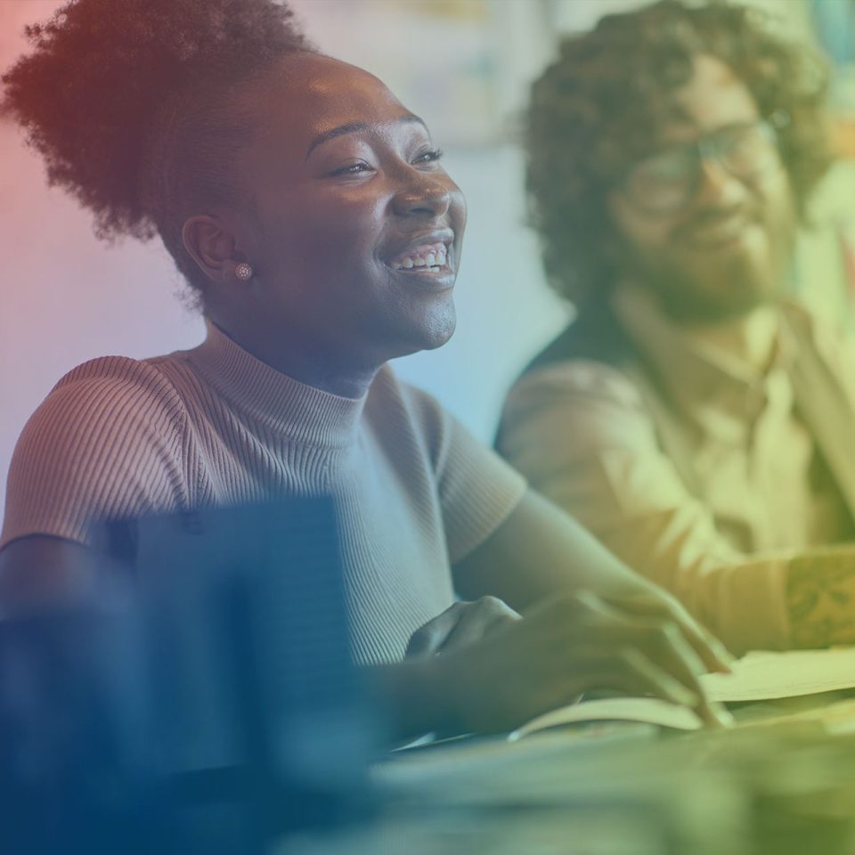 young woman smiles working at the office with her co-worker